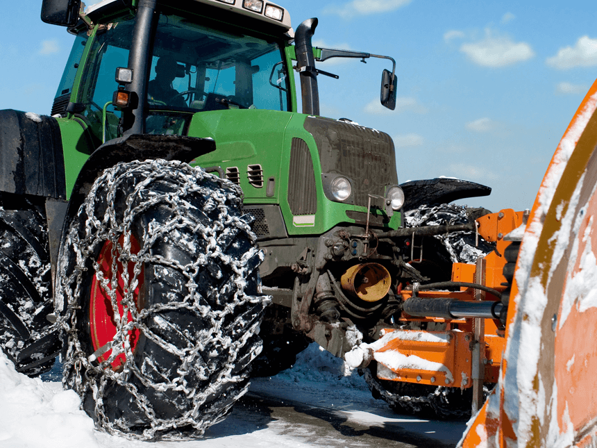 Grüner Traktor mit schwarzen Reifen und roten Felgen wird gereinigt