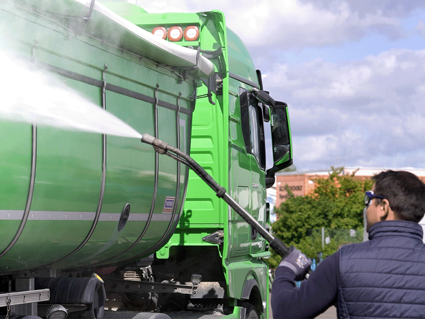 [Translate to Französisch:] Grünes Nutzfahrzeug, welches von einem Mann mit einem Druckreiniger gereingt wird